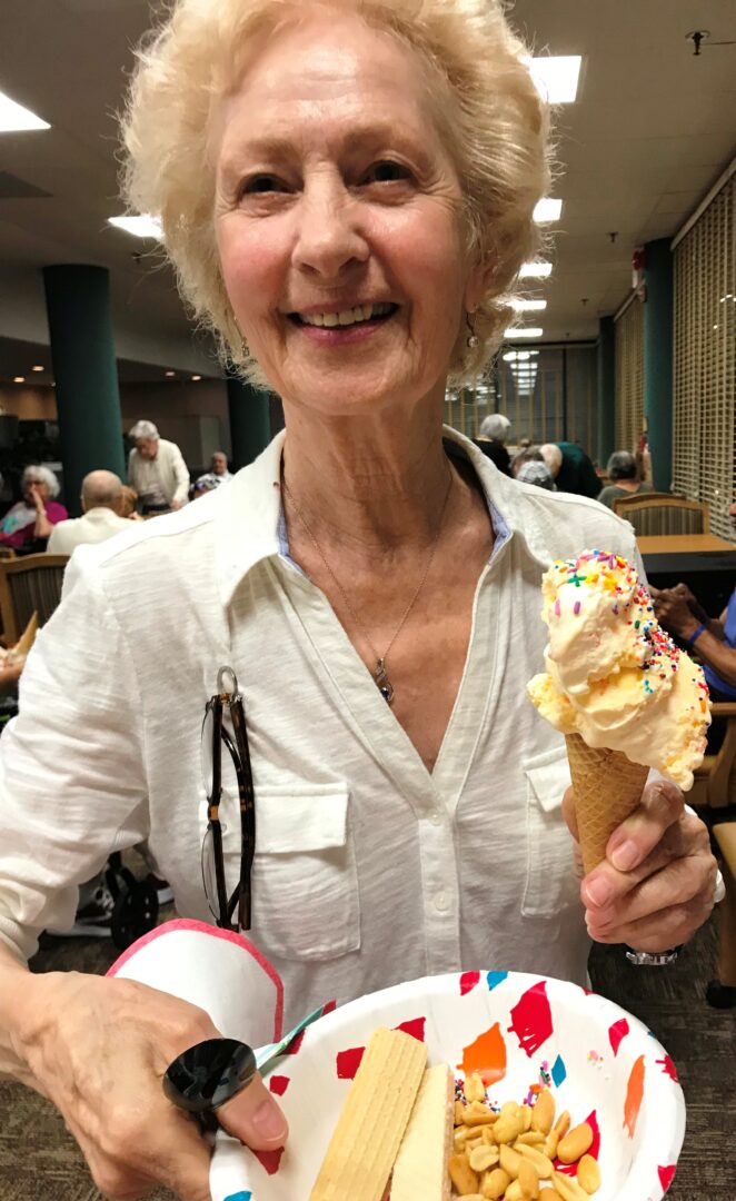 woman holding an ice cream and a plate of snacks