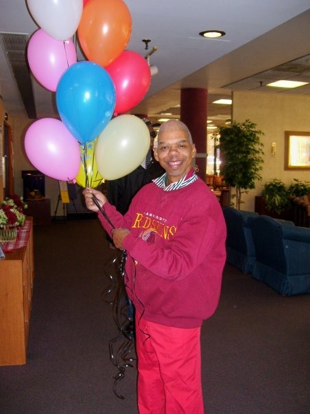 man in pink holding balloons